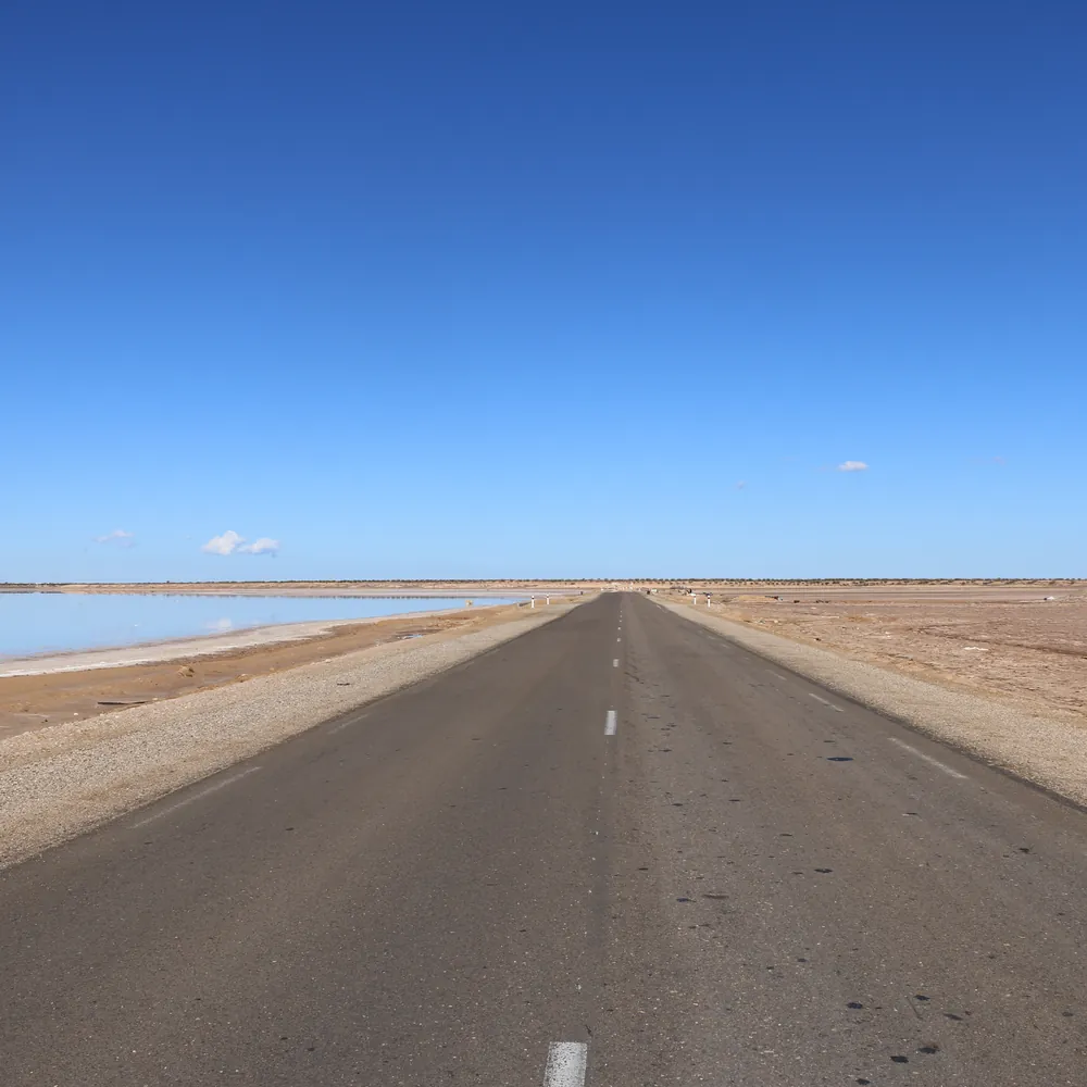 Route rectiligne traversant un chott du Sud tunisien